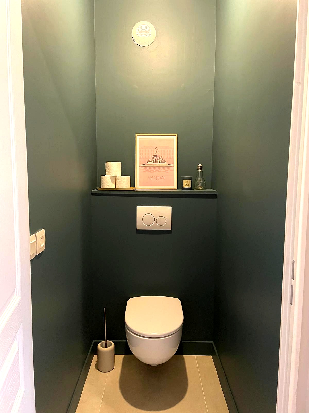 WC vert foncé avec affiche Nantes et toilette suspendue
